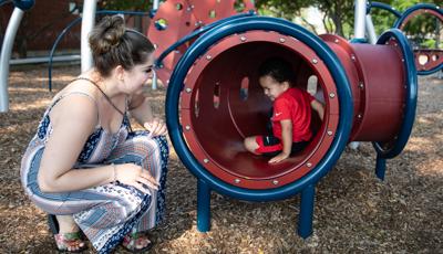 Boy playing in tunnel with mom looking in