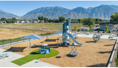 Elevated view of a playground at a sports Park with mountains in the background.
