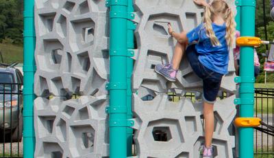 Girl on Geoplex climbing wall