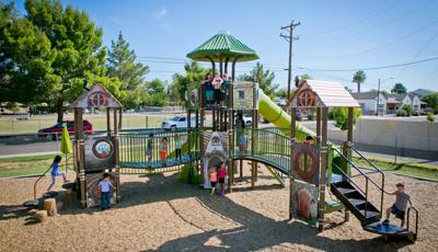 Children of Villa Montessori School playing on medieval-themed play structure. The bridges make it fun and easy to go from one castle to another. A group of children stand at the top point, near the tunnel slide, while other kids play on the ground level.