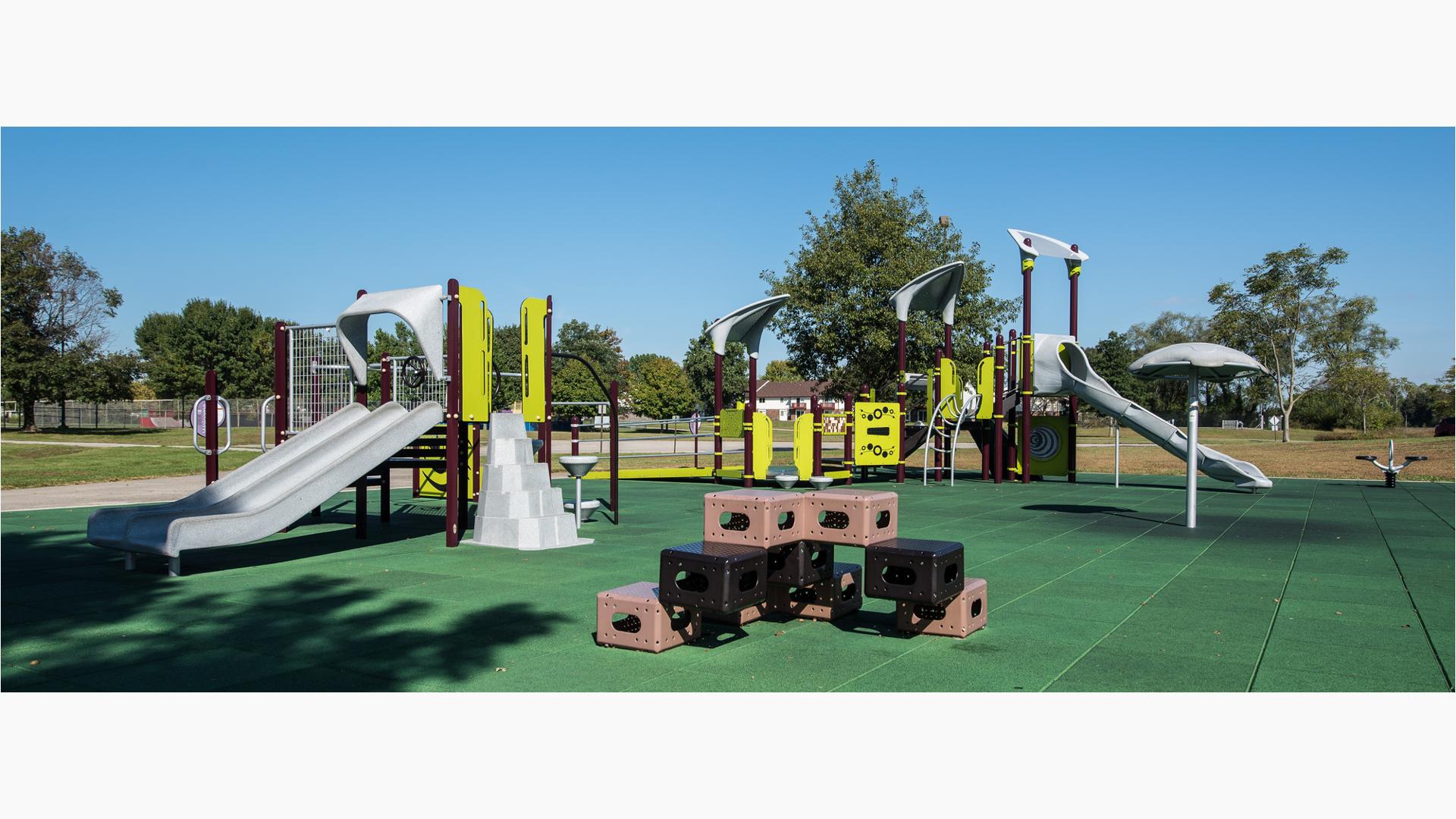 Modern-looking playground for kids ages 5 to 12 over green safety surfacing