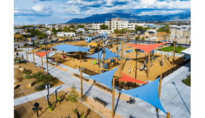Elevated view of a large play area with play structures and scattered shade sails covering structures and play activities.