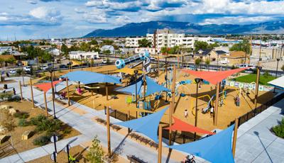 Elevated view of a large play area with play structures and scattered shade sails covering structures and play activities.