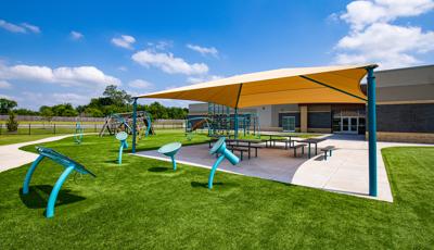 Rhapsody® Outdoor Musical Instruments sitting next to picnic table under SkyWays® Hip shade structure