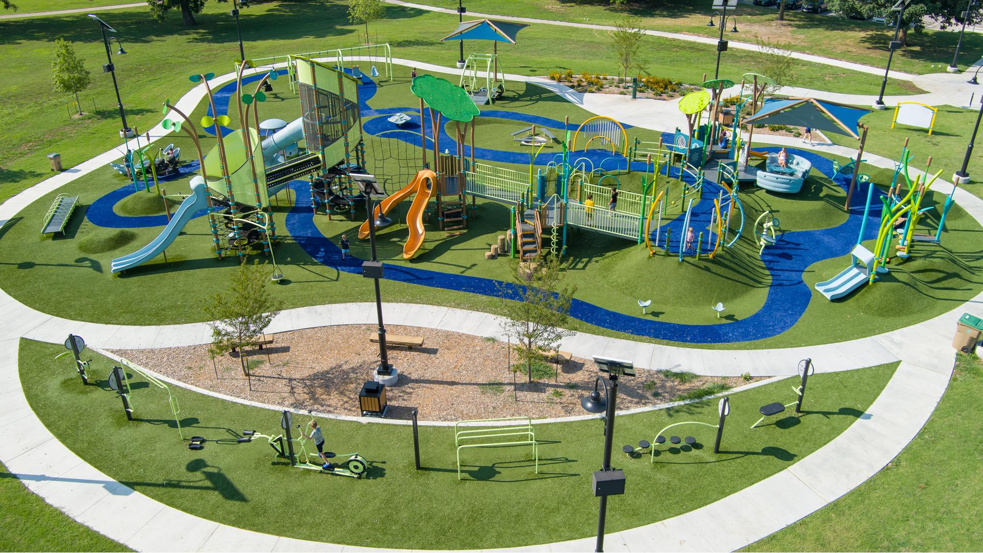 Elevated view of a large park play space with many playground structures, activities and a work-out section.