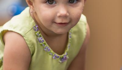 Little girl in yellow dress smiling