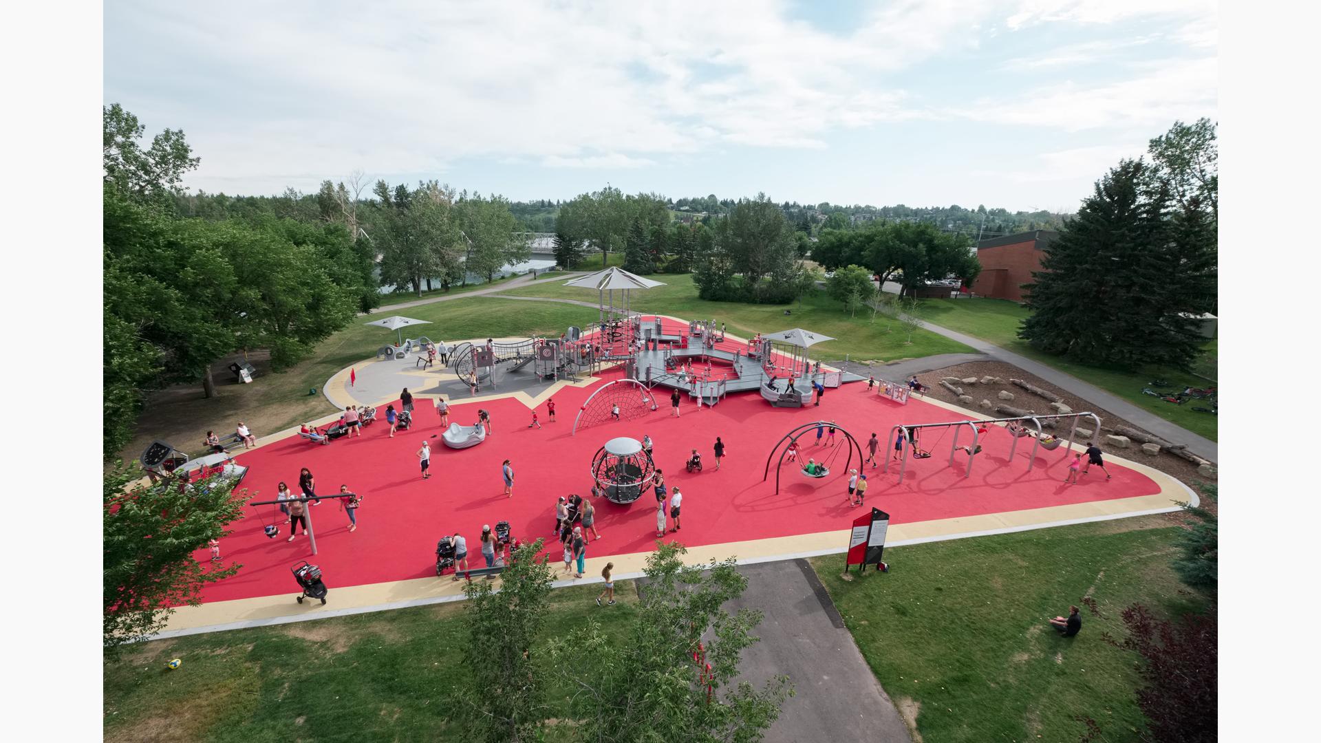 View over Shouldice Park. Families play on the Global Motion, the many swings and run along the access ramps.