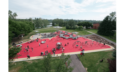 View over Shouldice Park. Families play on the Global Motion, the many swings and run along the access ramps.