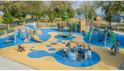 Elevated view of children playing on a boat and ocean themed playground.