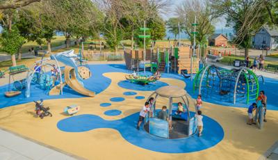 Elevated view of children playing on a boat and ocean themed playground.