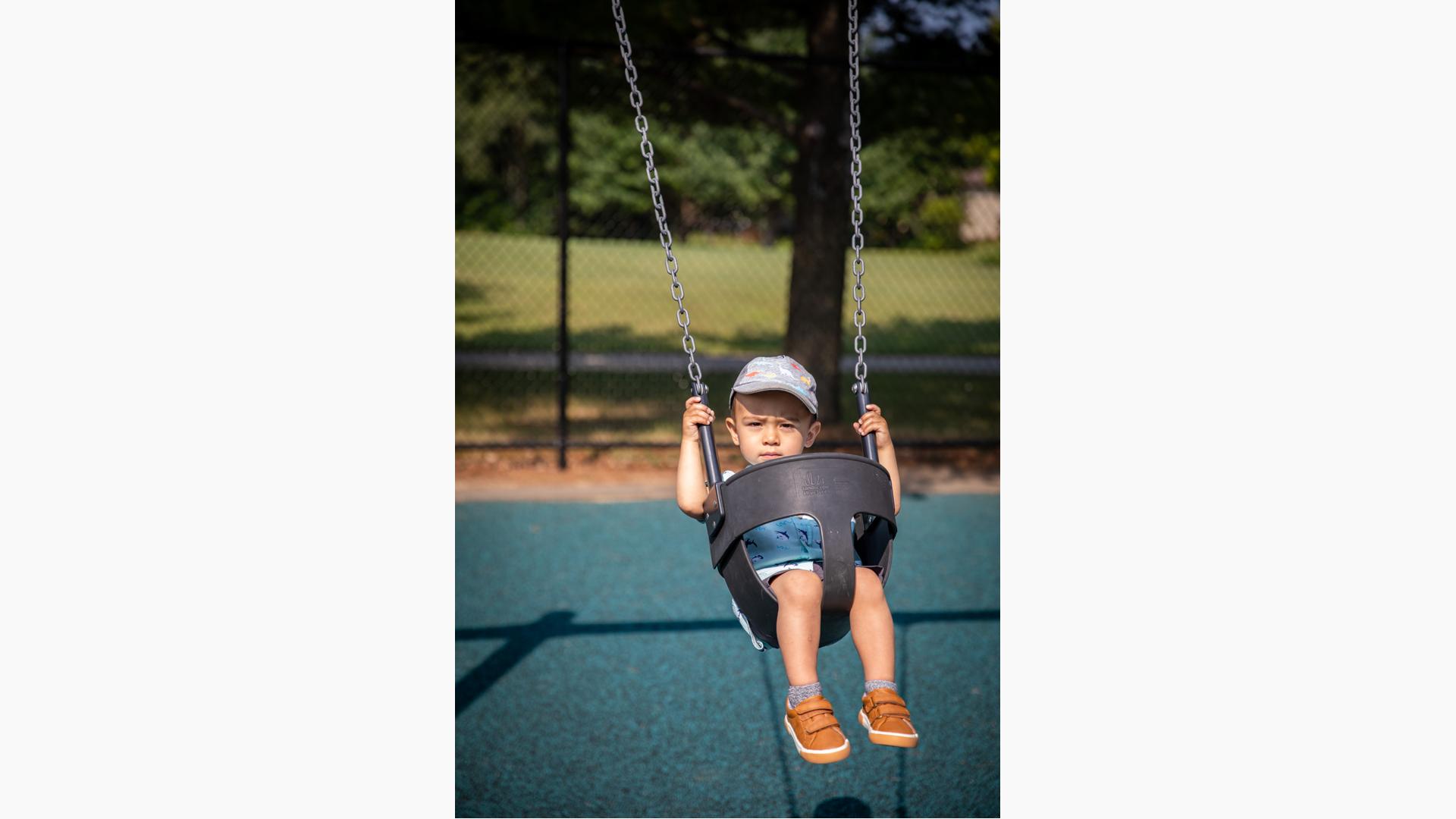 Child riding on bucket swing