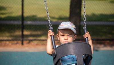 Child riding on bucket swing