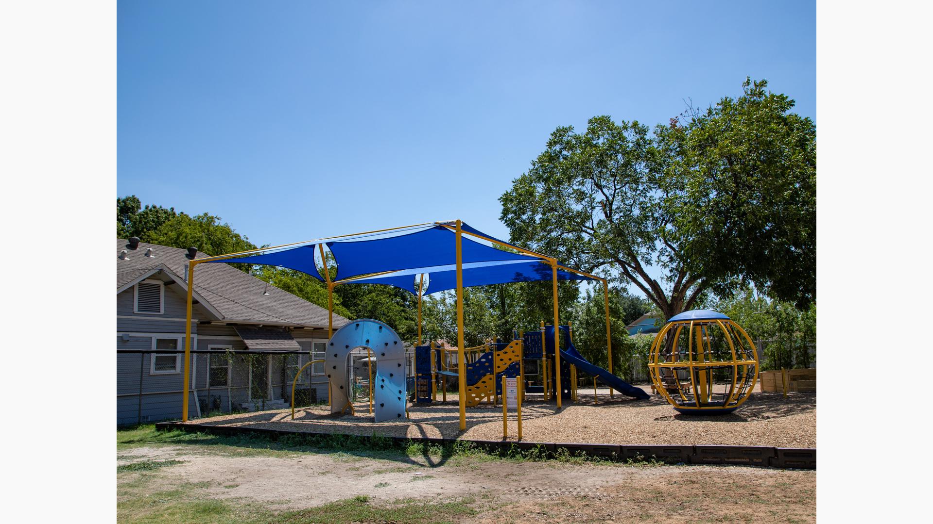 Two shade strutures cover this PlayBooster structure next to a Global spinner.