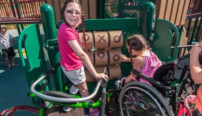 Girl smiling as she plays on tic-tac-toe panel with a friend