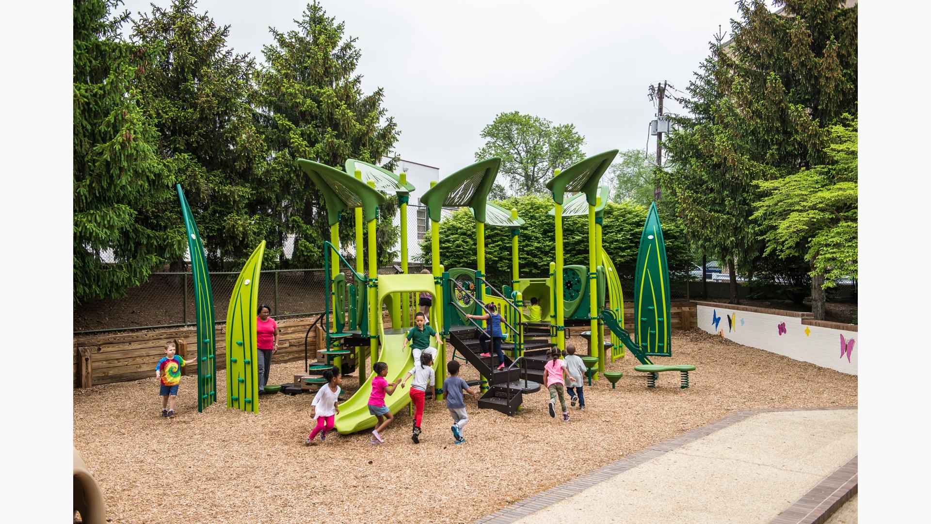 Children clamor and play on this custom playscape which is designed to look like you are playing in the garden with lots of green and leaf climbers. 