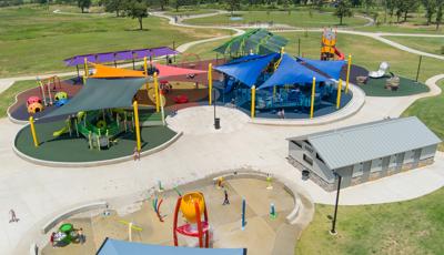 Elevated view of a large play space with corresponding colored shades sails to match the playground coloring below.