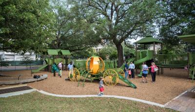 A little boy walks across a strip of concrete as families gather round the newly renovated "Pumpkin park" and enjoy the new play structures.