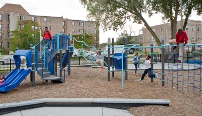 Children play on all the many playground activities at a community park.