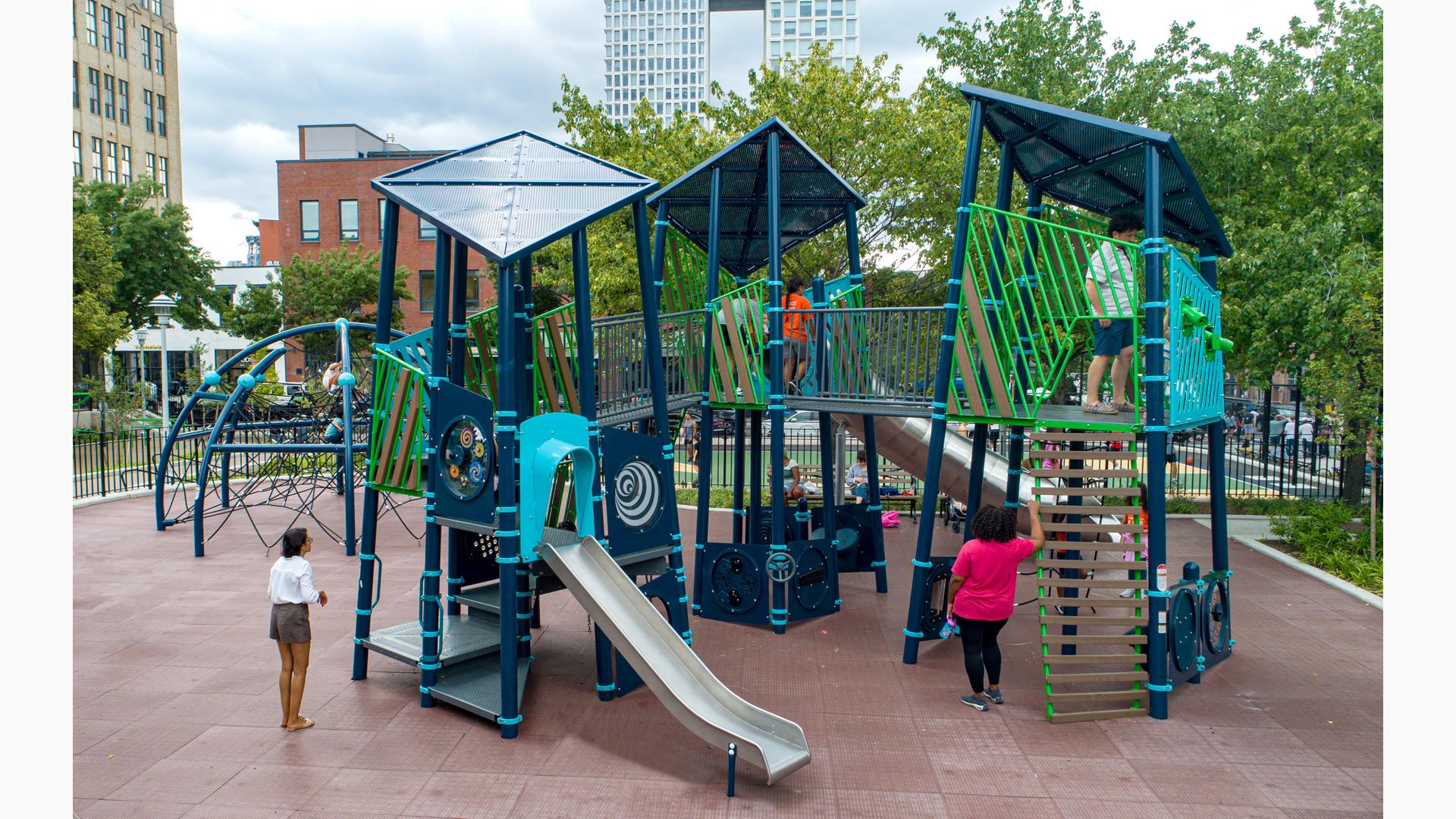 Elevated view of a custom city playground with unique geometrical roofs, wall panels, and climbers.