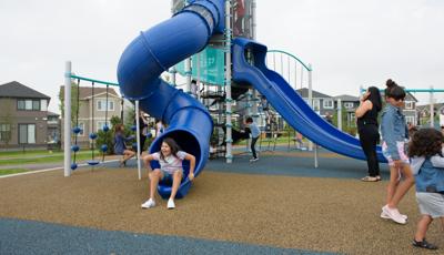 Girl smiling as she climbs out of windy tunnel slide