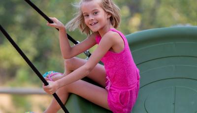 Girl smiling swinging on Oodle® Swing