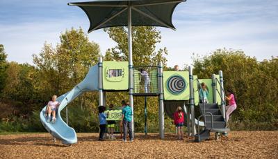 Children playing on a playground structure with fun interactive panels.