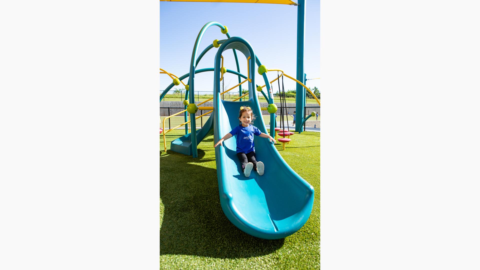 Girl in blue shirt riding Weevos slide