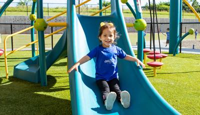 Girl in blue shirt riding Weevos slide