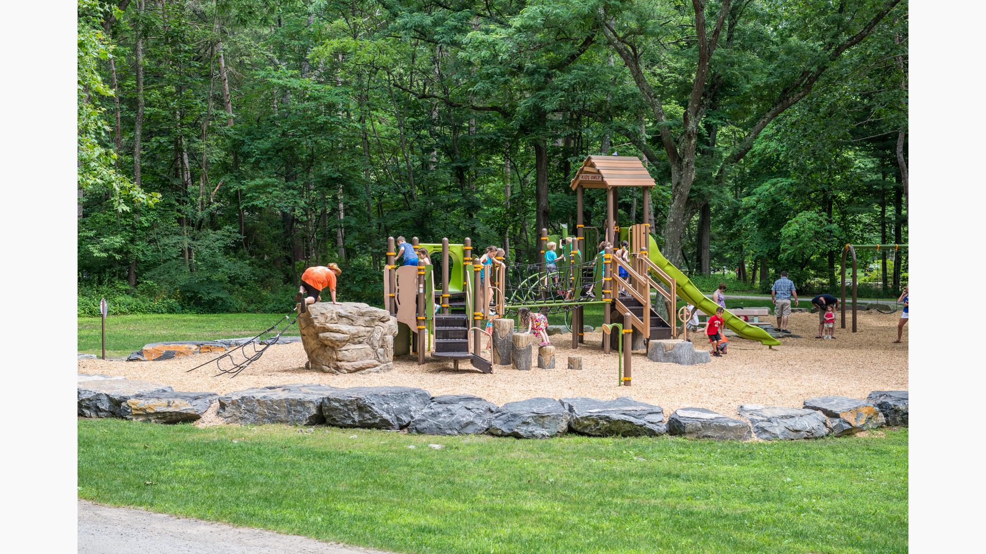 Kids climbing on naturally-themed playground in Robert H. Treman State Park.