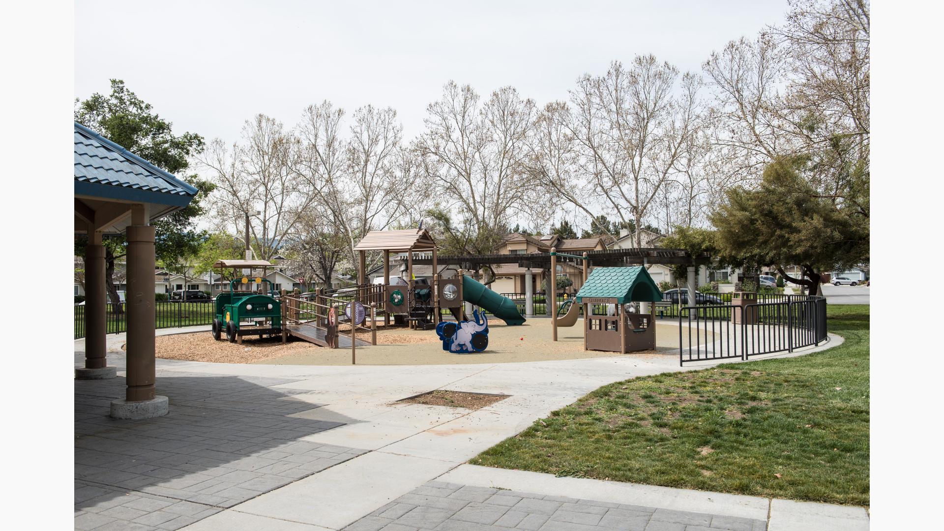 Safari-theme playground colored brown and green and includes accessible ramps. There is also a custom safari jeep. 