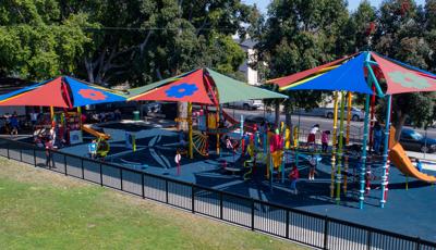 Lincoln Heights Recreation Center, Los Angeles, CA, a festive color scheme along with custom flower-printed SkyWays® shade sails.  Picado banner climbers, sugar skull steppers and DigiFuse® flowers.