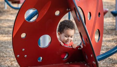 Little boy looking through hole of Play Shaper structure