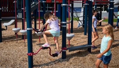 Girl in jean shorts watches friend in purple shirt riding Stationary Cycler