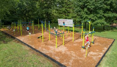 Full view of a fitness workout area with equipment spaced in an obstacle course setting allowing for teens and adults to get a full body workout. 