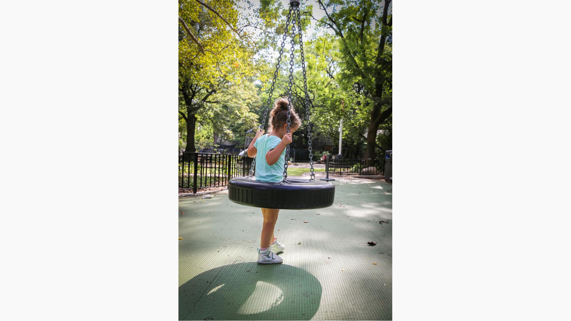 Girl standing in tire swing