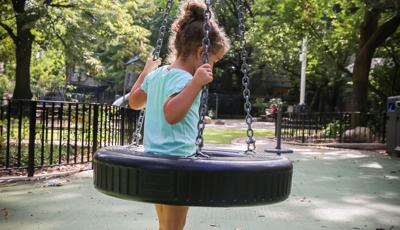 Girl standing in tire swing